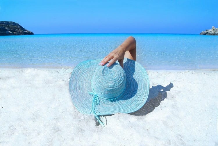 Rentière sur une plage grâce à son portefeuille de rentier